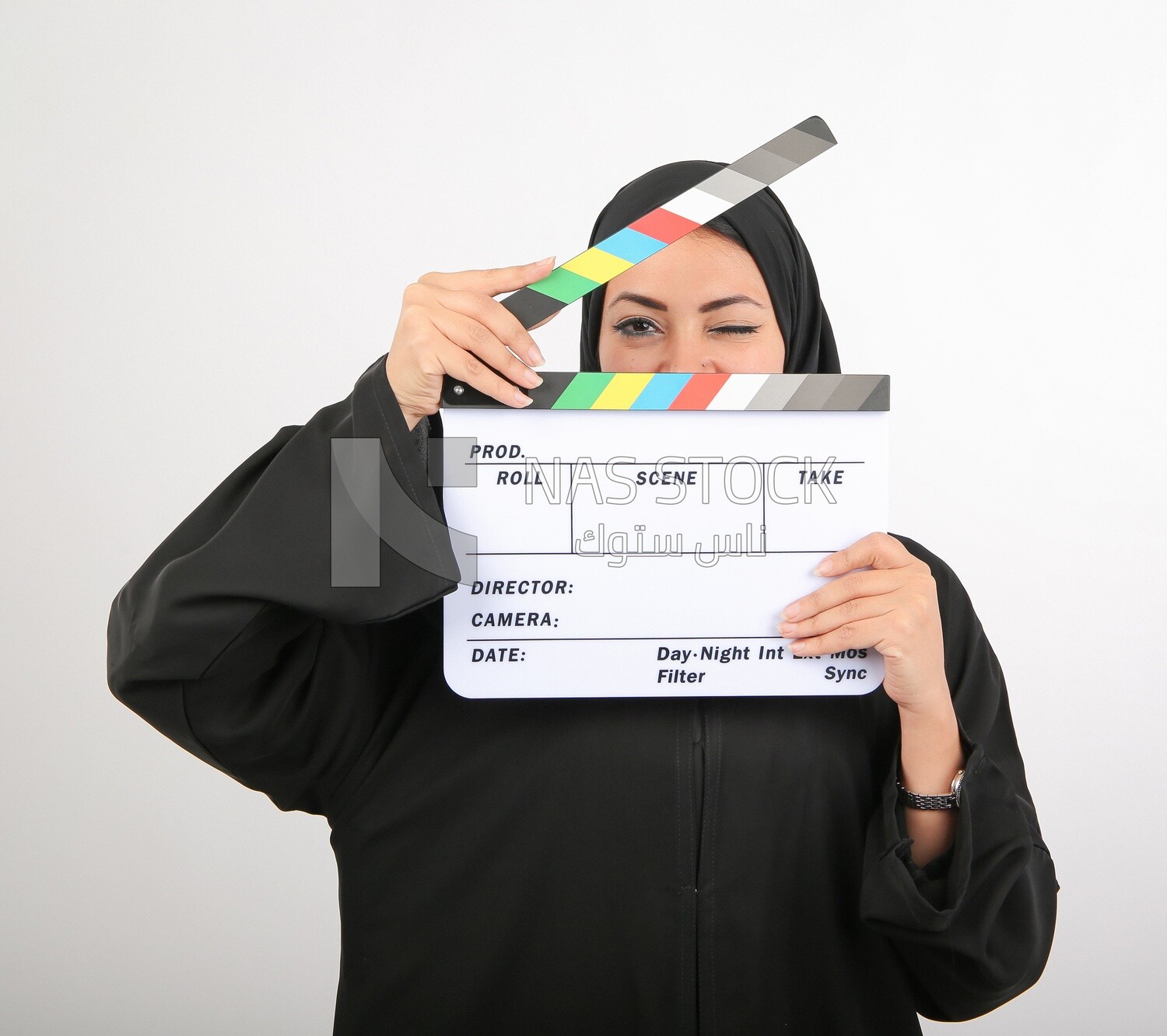A woman with a hijab holding a clapperboard