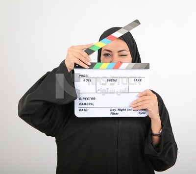 A woman with a hijab holding a clapperboard