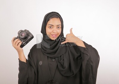 A woman with a hijab holding a camera