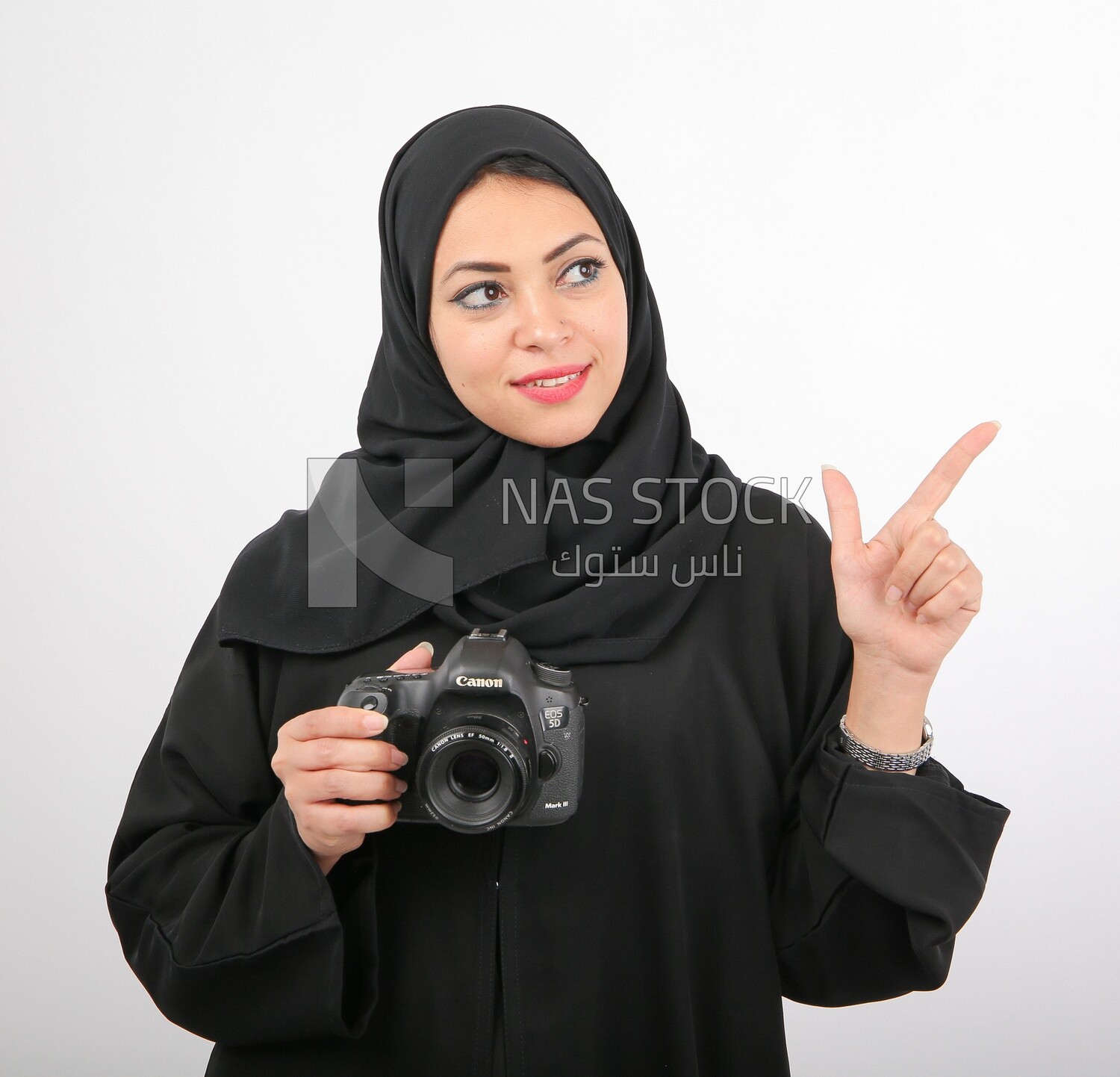 A woman with a hijab holding a camera