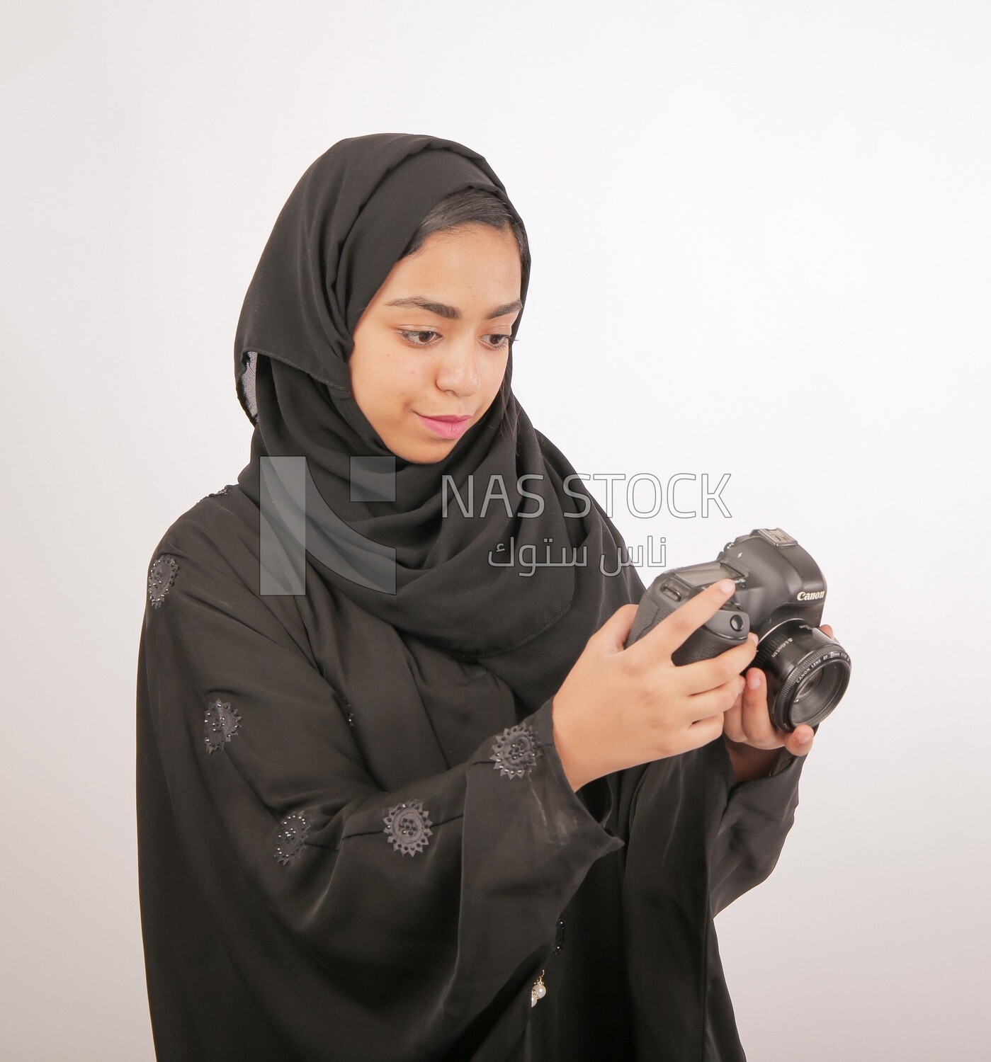 A woman with a hijab holding a camera