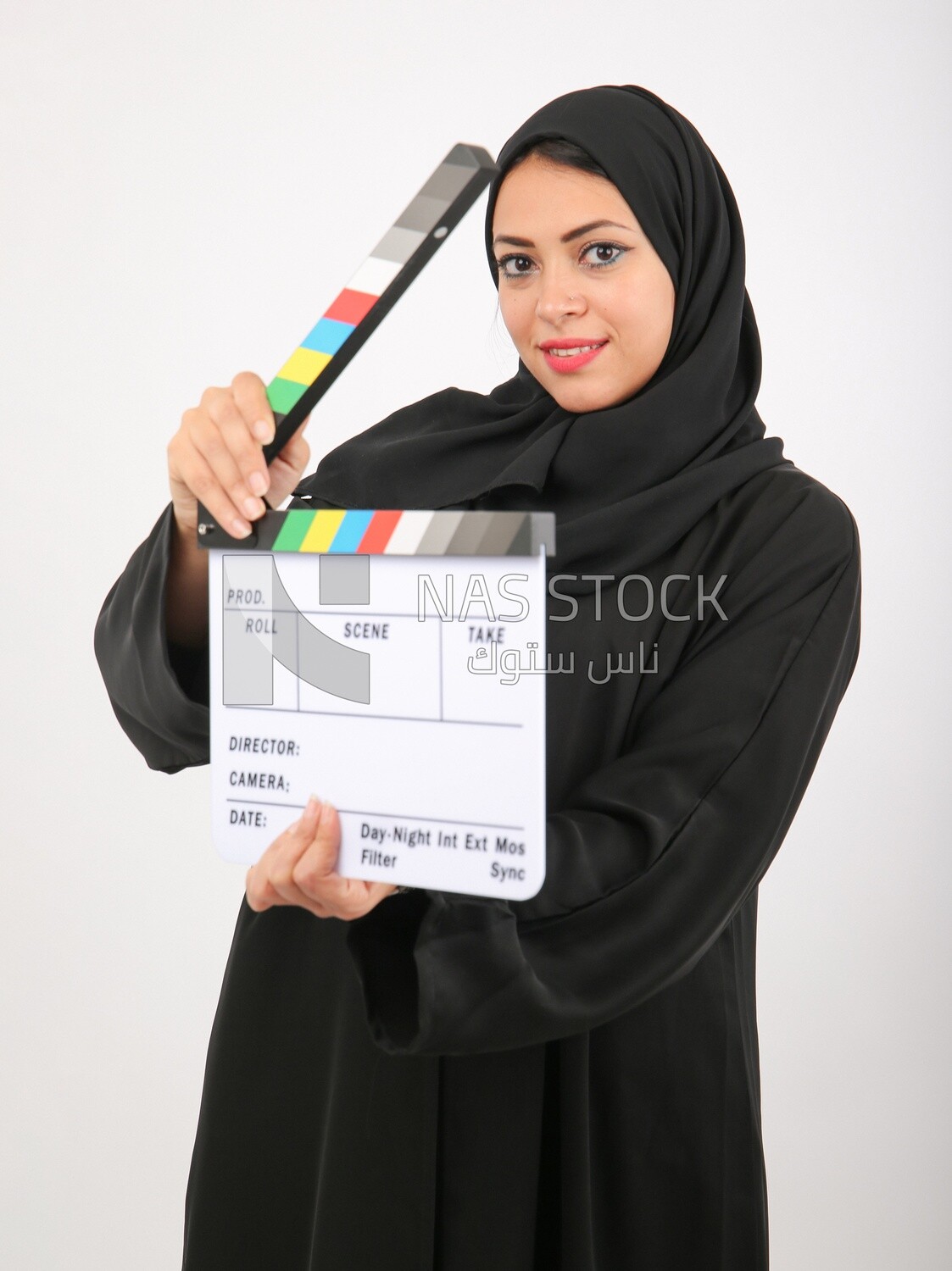 A woman with a hijab holding a clapperboard