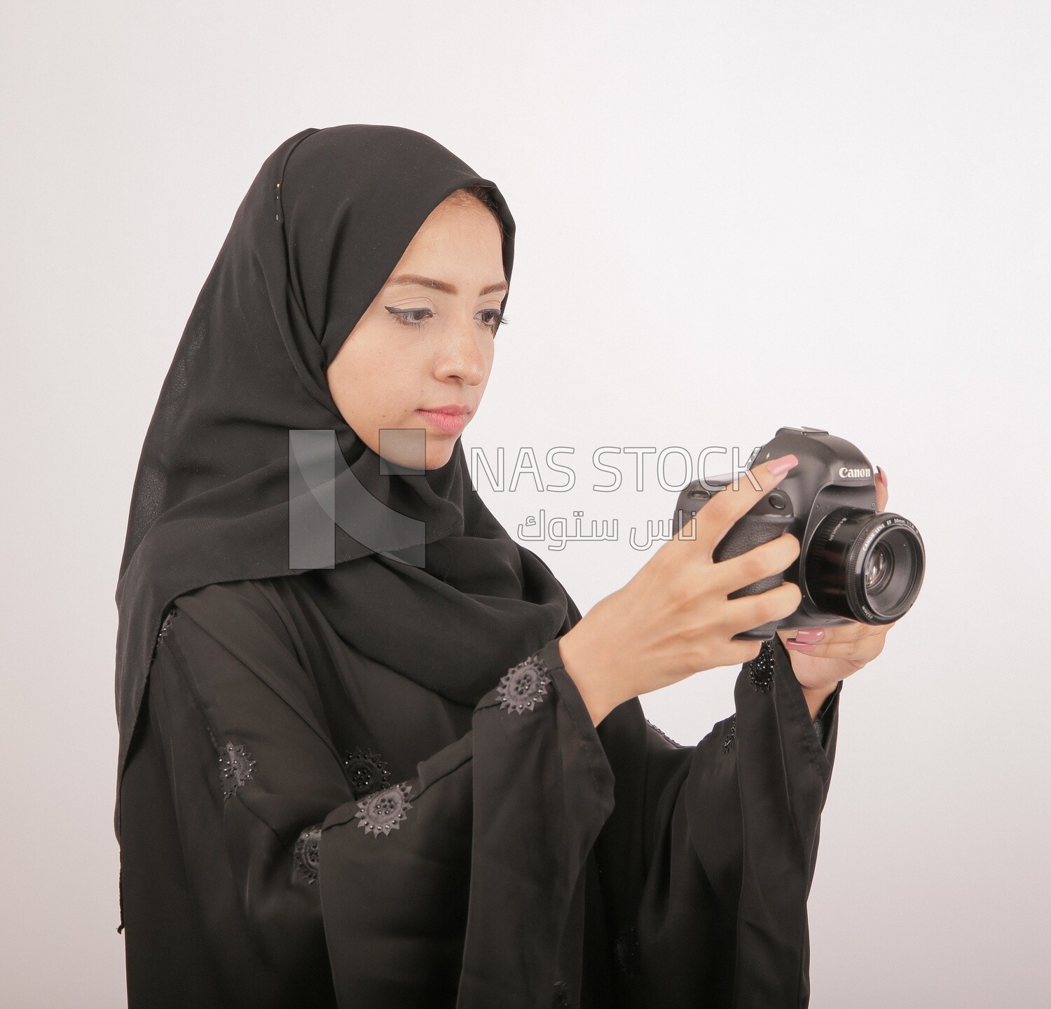 A woman with a hijab holding a camera