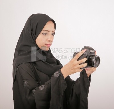 A woman with a hijab holding a camera