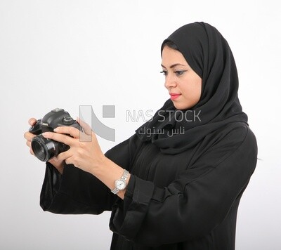 A woman with a hijab holding a camera