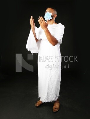 A man wearing an ihram dress with a mask