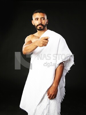 A man wearing an ihram dress pointing away