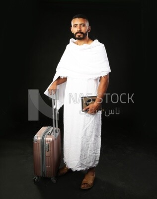 A man wearing an ihram dress prays