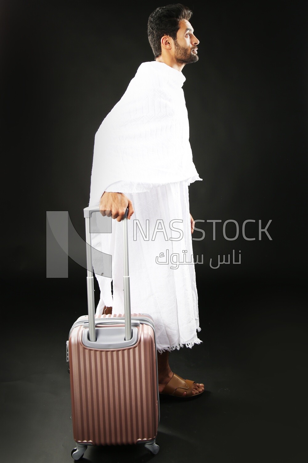 A man wearing an ihram dress with his luggage