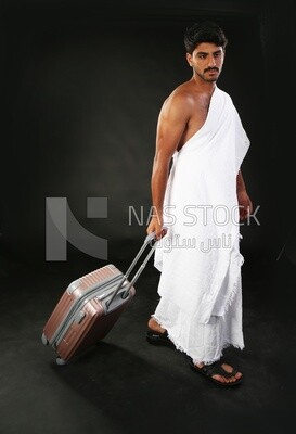 A man wearing an ihram dress with his luggage