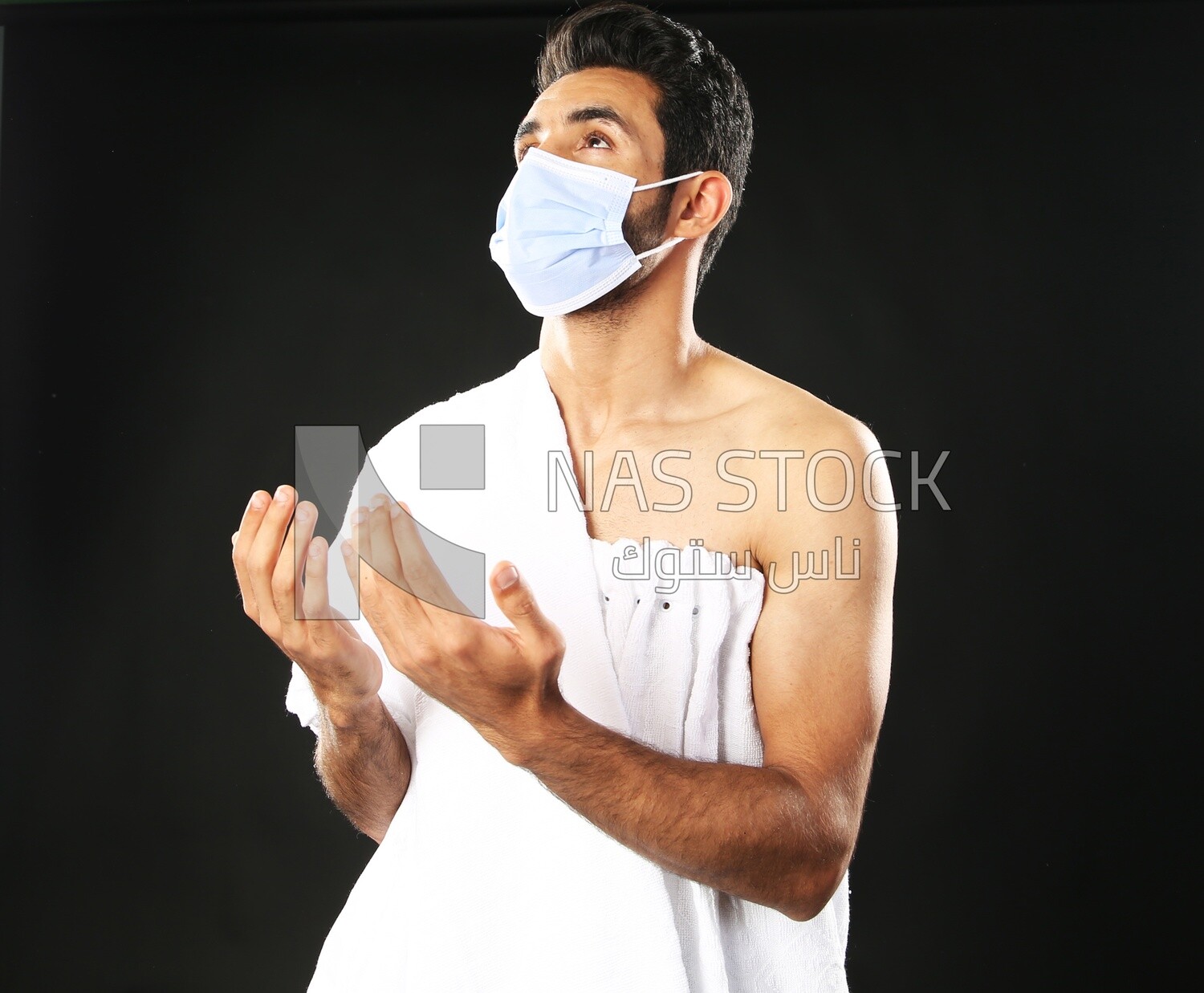 A man wearing an ihram dress with a mask