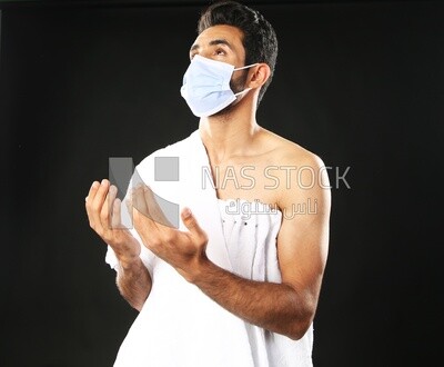 A man wearing an ihram dress with a mask