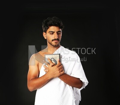 A man wearing an ihram dress prays