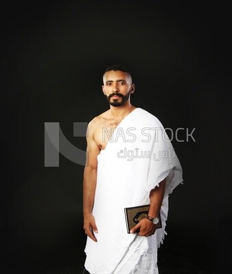 A man wearing an ihram dress prays