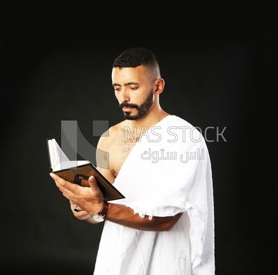 A man wearing an ihram dress prays