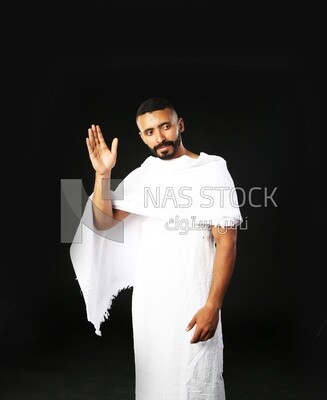 A man wearing an ihram dress and waving his hand ​