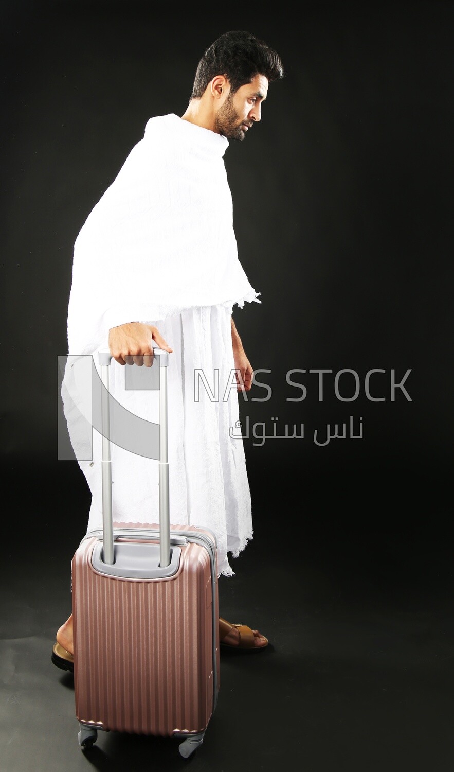 A man wearing an ihram dress with his luggage