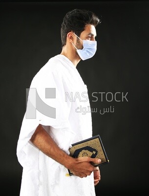A man wearing an ihram dress prays
