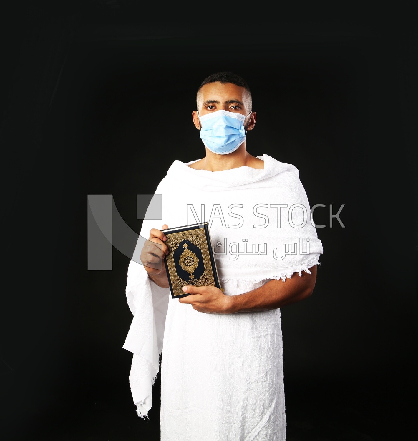 A man wearing an ihram dress prays