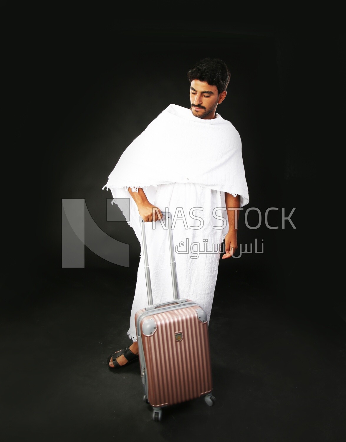 A man wearing an ihram dress with his luggage