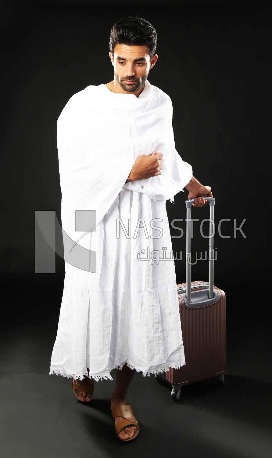 A man wearing an ihram dress with his luggage