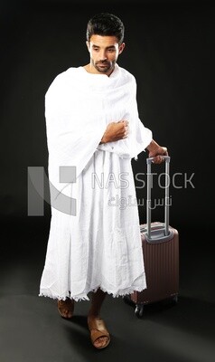 A man wearing an ihram dress with his luggage