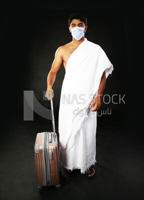 A man wearing an ihram dress with his luggage