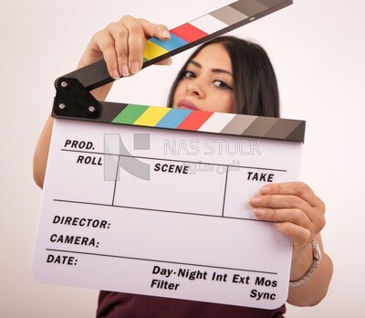 A woman holding a clapperboard on a white background ​