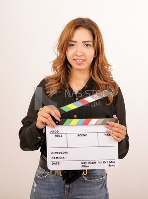 A woman holding a clapperboard on a white background ​