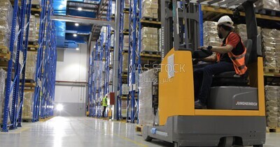 Man riding an order picker inside a store