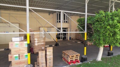 worker pulls a cart loaded with goods and cartons in a store
