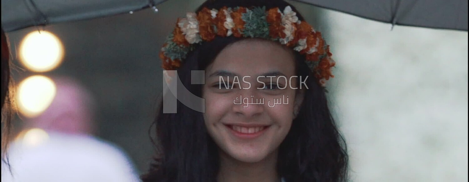 Beautiful girl wearing a wreath of Asiri roses and smiling, Saudi Arabia