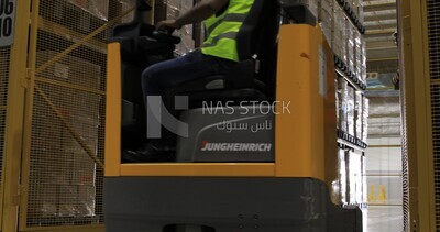 worker opens the doors of a cart loaded with cartons and goods