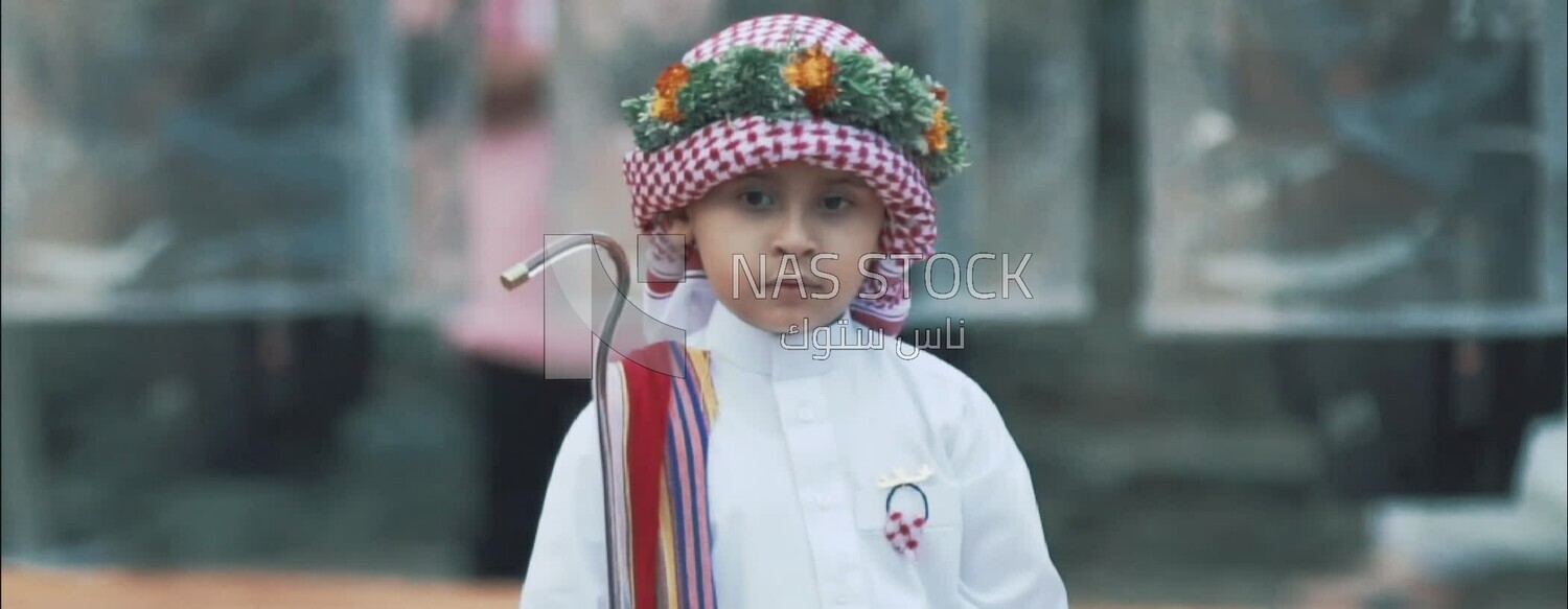Saudi child in traditional costume and wearing a wreath of Asiri roses, Saudi Arabia