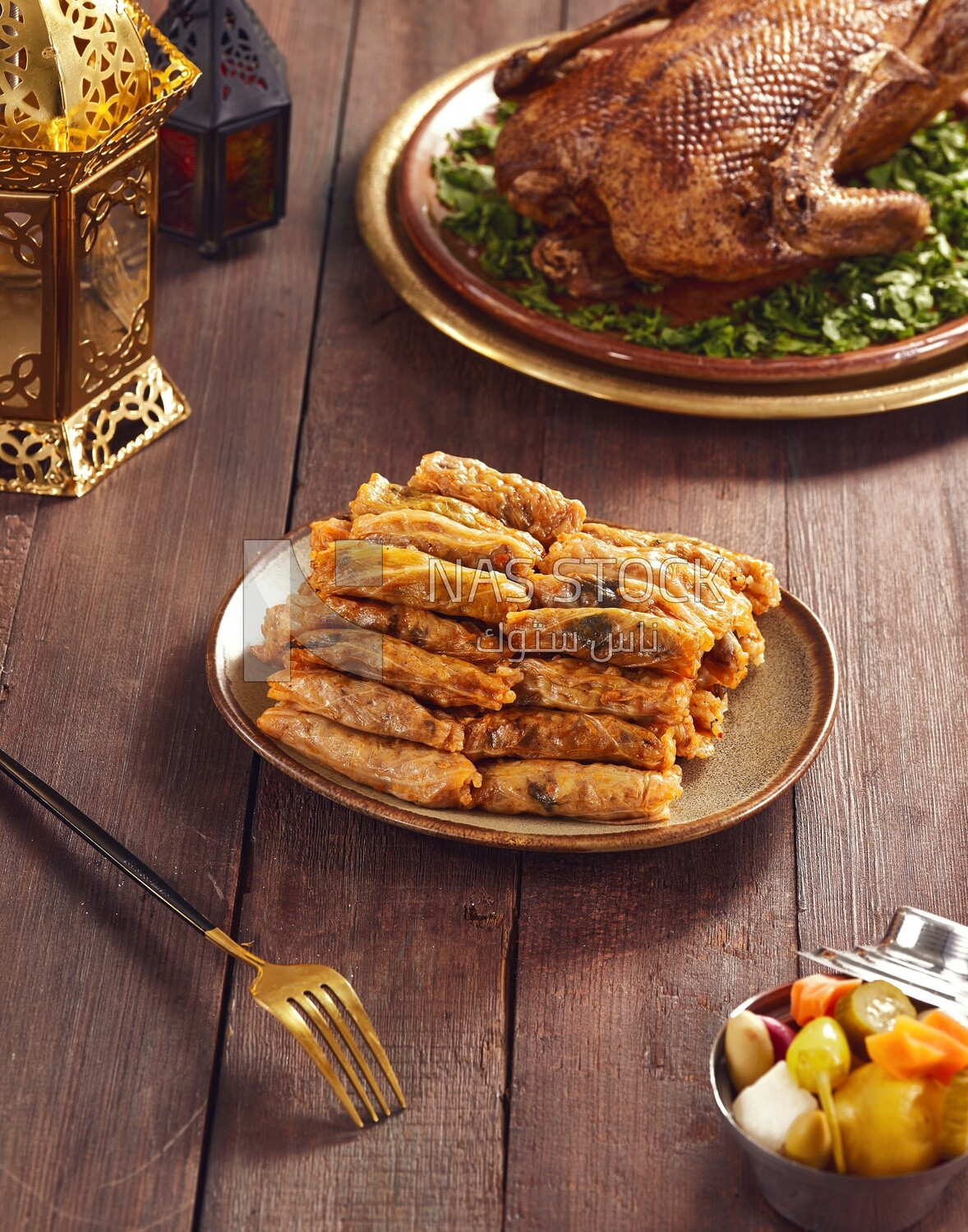 Side view of  Dining table with stuffed cabbage leaves and roast duck