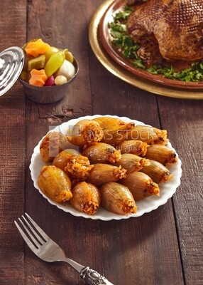 Side view of a scene from a Dining table with Stuffed onions and roast duck