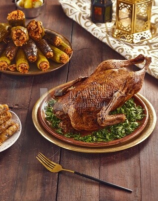 Side view of a scene from a Ramadan lunch table with roast duck and  different types of stuffed vegetables