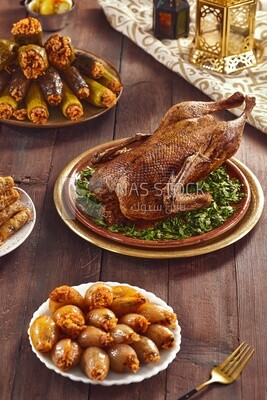 Side view of a scene from a Ramadan lunch table with roast duck and  different types of stuffed vegetables