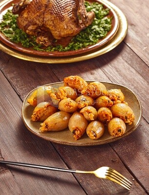 Side view of a scene from a Dining table with Stuffed onions and roast duck