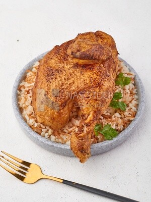 Side view of a plate of rice with chicken on a white background