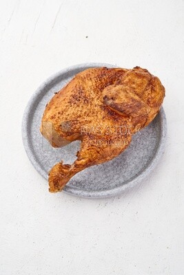 Top view of a grilled chicken on a white background