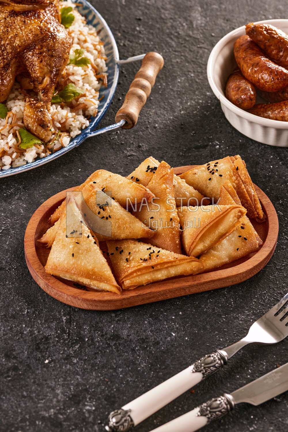 Side view of a dining table with Samosa ,chicken rice and Mombar