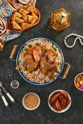 Top view of a Ramadan dining table with chicken rice, samosa, mombar  and soup