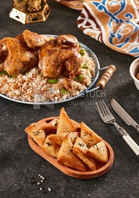 Side view of a dining table with samosa and chicken rice