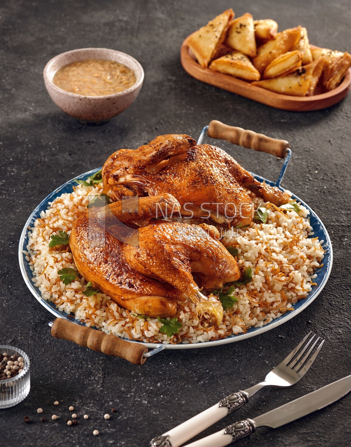 Side view of a dining table with chicken rice, samosa and soup