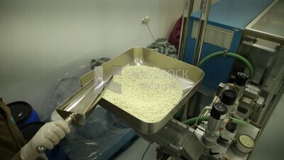 Specialist places the white medicine tablets in the nozzle of the machine to collect them in medicine strips.