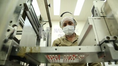 Doctor supervises the sorting and pressing of Medication tablets before packaging