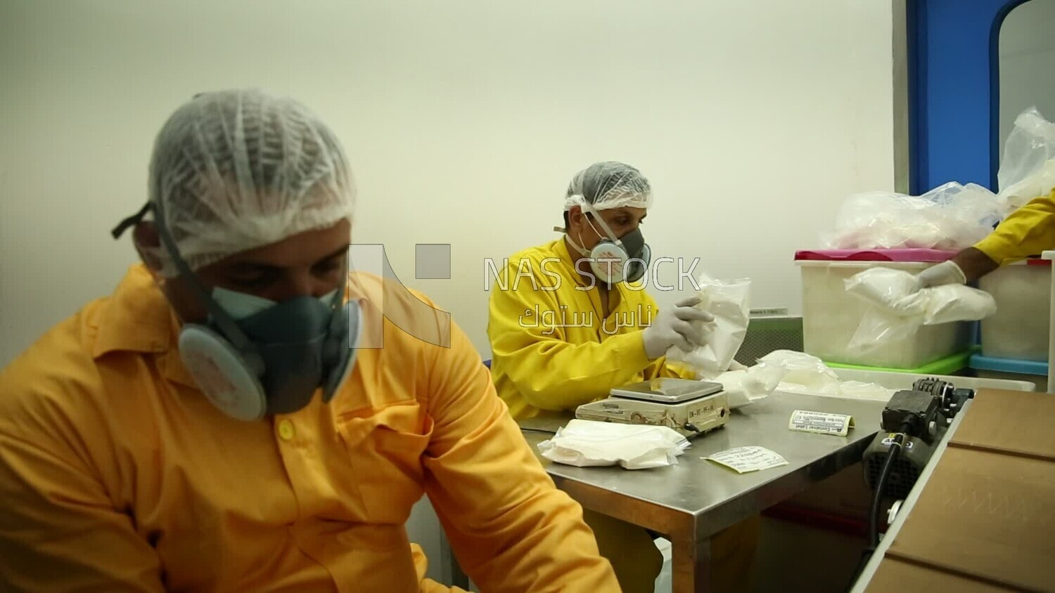 Two specialists in a pharmaceutical factory ensure the safety of bags of drug powders