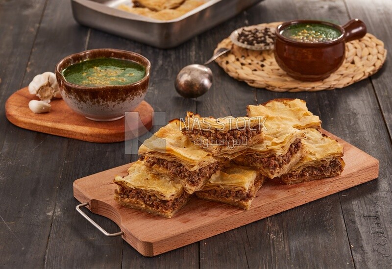 Plate of Molokhia and crispy Phyllo Meat Pie (Egyptian goulash), traditional Arabic dishes, Arabic food, popular dishes, delicious recipes and dishes, delicious food