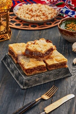 Plate of Molokhia, white rice, and crispy Phyllo Meat Pie (Egyptian goulash), traditional Arabic dishes, Arabic food, popular dishes, delicious recipes and dishes, delicious food